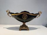 a black and gold bowl sitting on a white table