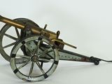 an old model of a cannon sitting on top of a white surface