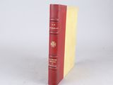 a red book with a yellow cover sitting on a white surface