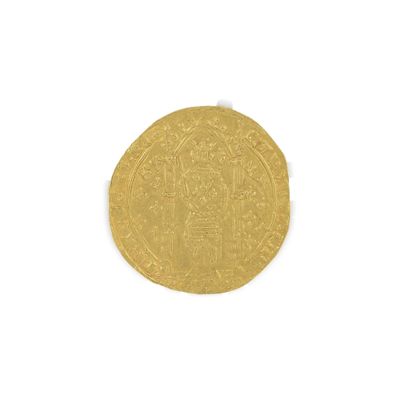 gros plan d'une pièce d'or sur une surface blanche