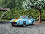 a blue and orange sports car parked in front of a tree