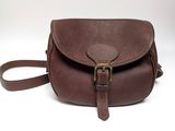 un sac à bandoulière en cuir marron muni d'une boucle métallique