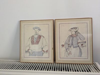 deux dessins encadrés représentant des hommes, posés sur une étagère dans une pièce