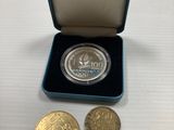 une pièce d'argent et deux pièces d'or dans une boîte bleue