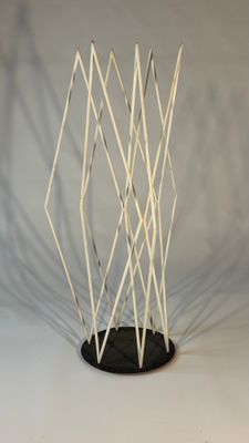 a sculpture made out of white sticks on a black base