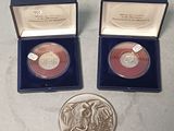 Il y a deux pièces d'argent dans une boîte bleue et une pièce d'argent dans une boîte bleue