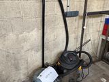 un aspirateur posé par terre près d'un mur
