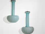 deux vases posés contre un mur blanc