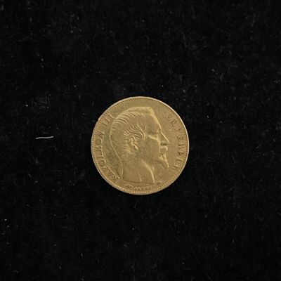 a close up of a gold coin on a black surface