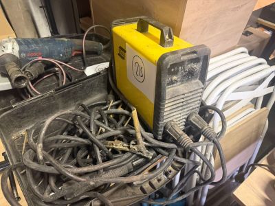 une soudeuse jaune posée au sommet d'un tas de fils