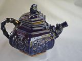 a blue and gold teapot sitting on a white table