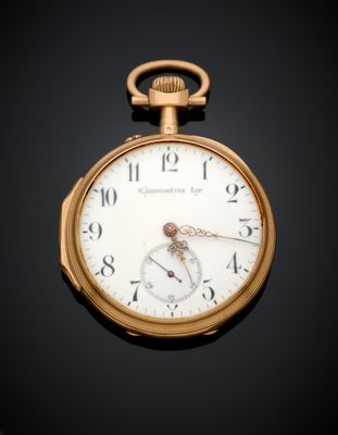 gros plan d'une montre de poche en or sur une surface noire