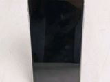 the back of a black cell phone sitting on top of a white table