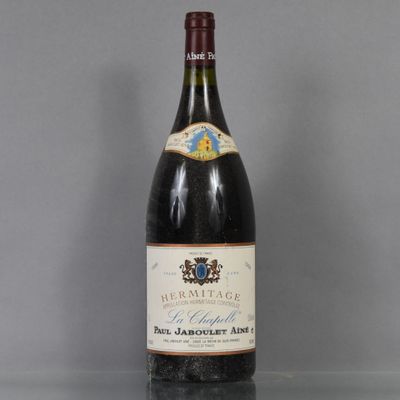 an old bottle of wine sitting on top of a glass table