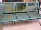un banc vert qui se trouve dans une pièce