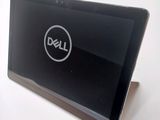 dell laptop computer sitting on a white surface with a dell logo on the screen