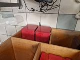 two wooden boxes with red boxes inside of them