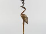 an image of a bronze statue of a crane on a turtle