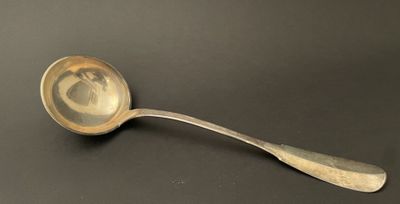 a silver spoon with a picture of a woman on it