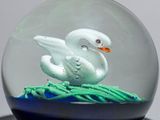 a glass ball with a white swan inside of it