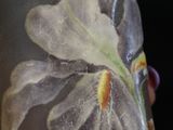 a close up of a vase with a flower painted on it