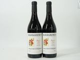 two bottles of red wine sitting next to each other on a table