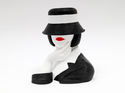 une figurine représentant une femme portant un chapeau et une écharpe