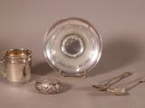 une assiette en argent et une tasse en argent posées sur une table