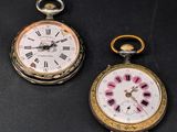 two clocks that are sitting next to each other on a table
