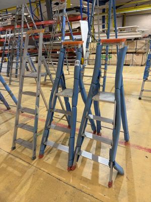 many ladders that are sitting in the middle of a room