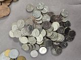 a pile of coins sitting on a table next to a calculator