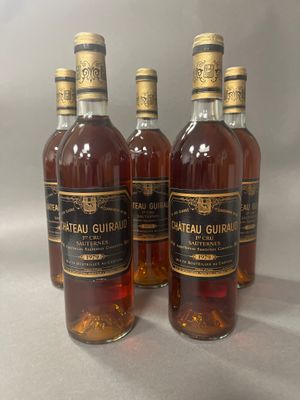 Quatre bouteilles de Château Guiait sont alignées sur une table
