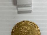 gros plan d'une pièce d'or sur une surface blanche