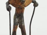 statue of a man with a horned head holding a cane