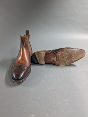 pair of men ' s brown leather shoes on a gray surface