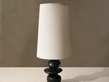 a black lamp with a white shade on a table