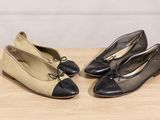 two pairs of black and white shoes sitting on top of a wooden table