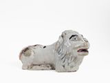 a small statue of a dog on a white surface