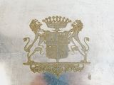 a silver plate with a gold emblem on it