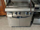 a large stainless steel grill in the middle of a kitchen