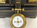 a clock that is sitting on a table with two candles