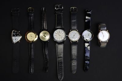 cinq modèles de montres différents sur un fond noir