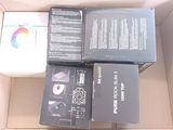 quatre boîtes contenant du matériel électronique, rangées dans un carton