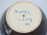 a brown and white vase with blue writing on it