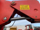 a large red crane with a yellow sign on it