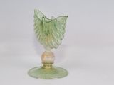 une figurine en verre surmontée d'une feuille verte