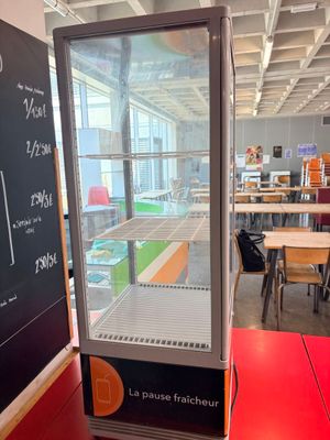 tables and chairs in a room with a chalk board on the wall