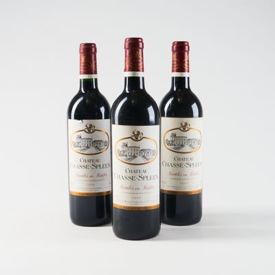 three bottles of red wine sitting on top of a white table