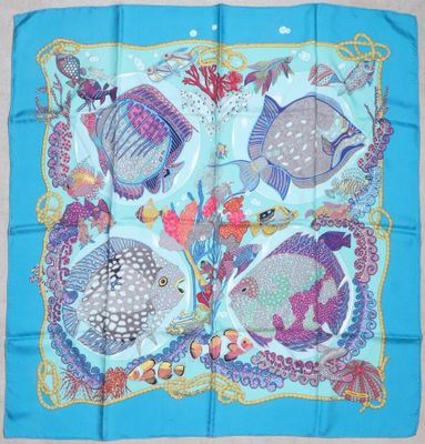 a close up of a blue scarf with fish on it