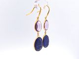 a close up of a pair of earrings hanging from a glass